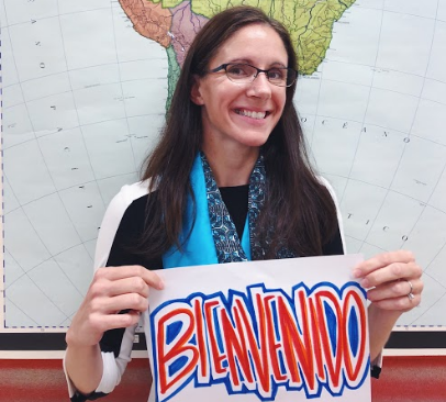 Mrs. Angela Gardner, Spanish Club Adviser, holds a welcome sign in Spanish.