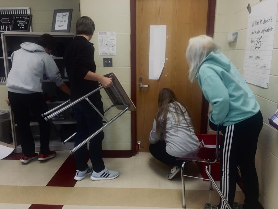 RHS students begin barricading a classroom door to practice ALICE training.