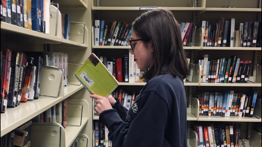 Senior Juliana Curtis picks up a copy of The Perks of Being a Wallflower while browsing the media center.