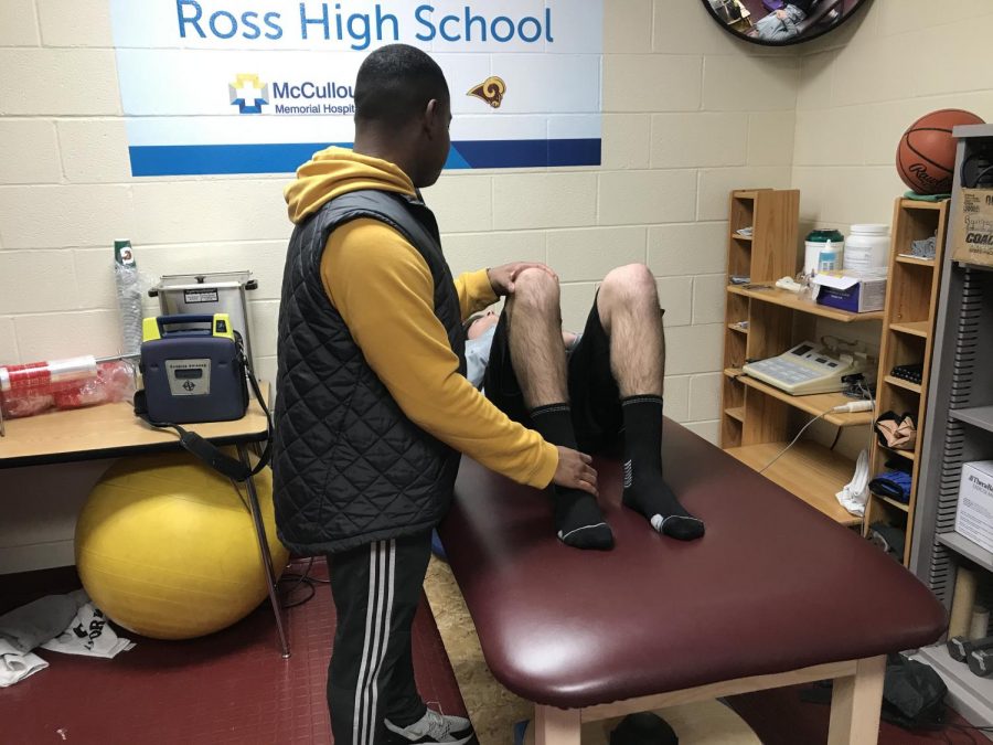Khari helps an athlete with his knee.