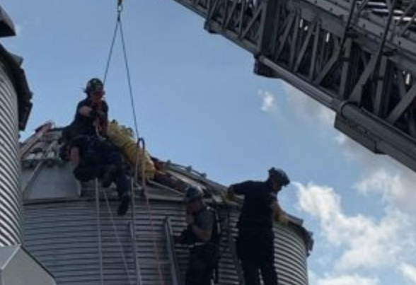 Jay Butterfield is rescued by several fire department officials from a grain bin in Ross, OH.