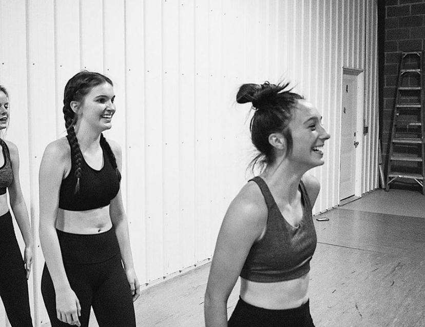 Dance students Estella Varner and Mary Southwick share a laugh during rehearsal. 
