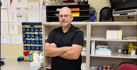 Scott Canfield, Psychology and Sociology teacher at Ross High School posing in his room, showing how confident you can be with his stress relieving tips. 
