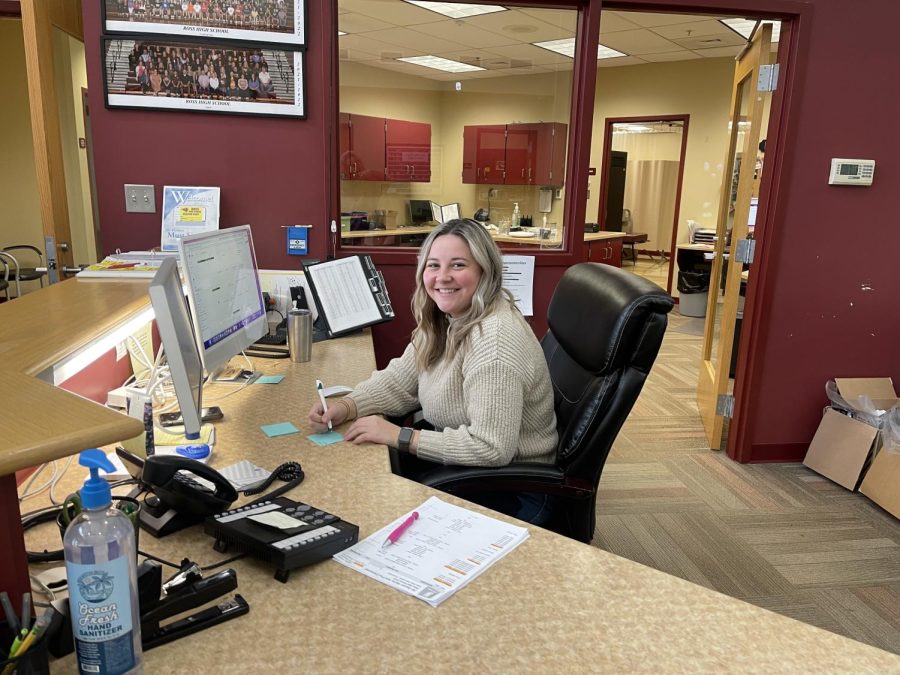 Mrs. Emmalee Forch sits at her desk in the front office of Ross High School.