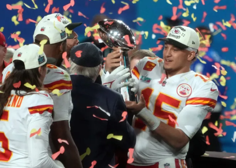 Chiefs’ quarterback Patrick Mahomes celebrates their Super Bowl win with his teammates and coaches while hoisting the Lombardi Trophy.