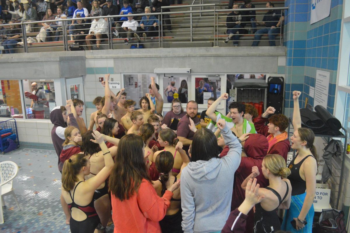 The RHS swim team breaks into a cheer before the meet.